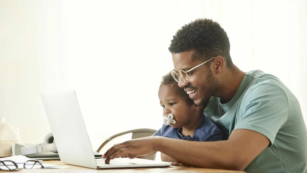 Decision Science | Arts & Culture Fundraising | Father holding son while working on a laptop - slide